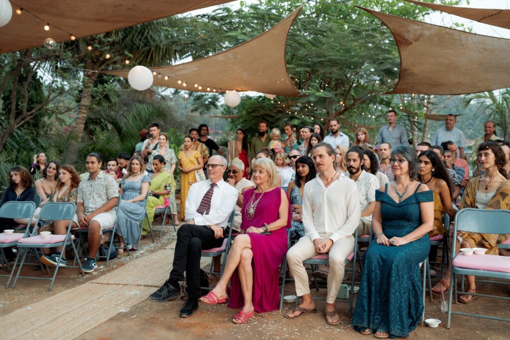 Guests Witnessing Vows at a Beachside Wedding in South Goa Wedding guests seated and watching the couple exchange vows at Kala Bahia, a scenic beachside wedding venue near Palolem Beach in South Goa.